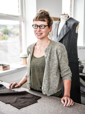 The image shows a student learning to create a bespoke jacket