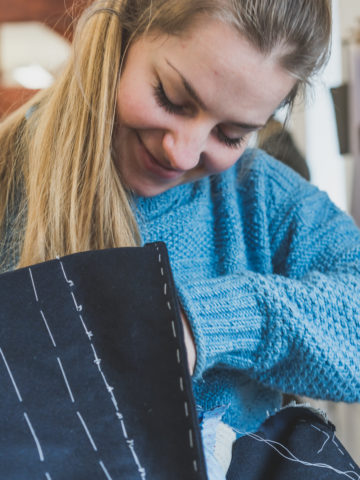 A female student learning to make a bespoke jacket by hand.