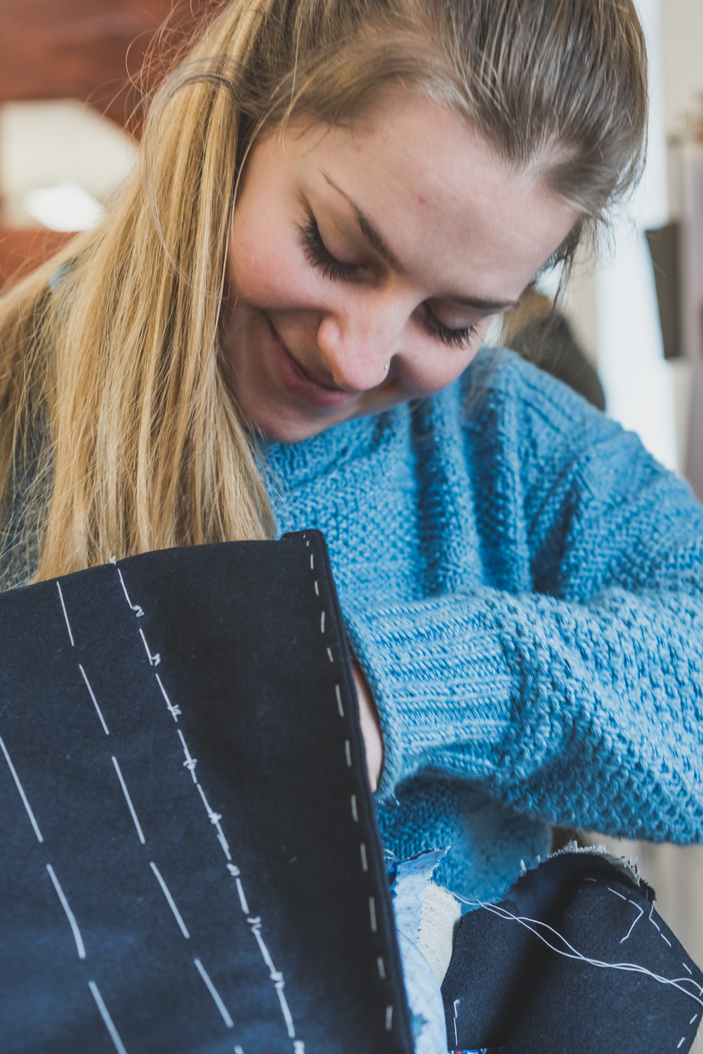 A female student learning to make a bespoke jacket by hand.